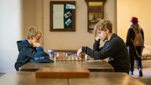 Two boys playing chess in the basement at Ickworth